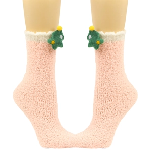 Detail einer rosa Plüschsocke aus Korallenfleece mit grünem Weihnachtsbaum und gelbem Stern