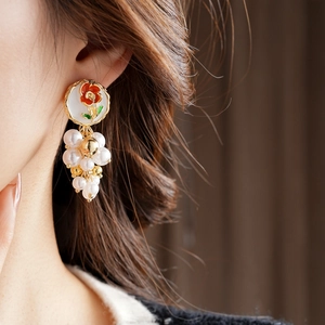 Gros plan de boucles d'oreilles vintage fleurs émaillées et perles blanches