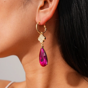 Detail of rose red teardrop crystal earring with clover pattern on female model