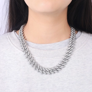Close-up of a silver iced-out Cuban link necklace with rhinestones on a male model