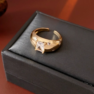 Detailaufnahme eines goldenen Vintage-Rings mit quadratischem Zirkon und kleinen Steinen