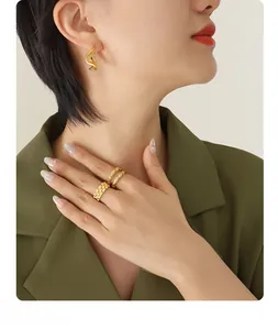 Close-up of elegant 18K gold-plated irregular wavy earrings and rings set on a model