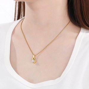 Detail of elegant gold teardrop necklace featuring a sparkling round zircon on model neck