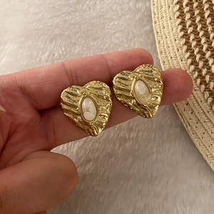 Vintage gold heart stud earrings with white oval stone inlay and hammered metal texture
