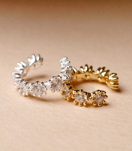 Macro shot of gold and silver ear cuffs with sparkling white zirconia stones