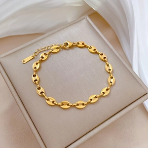 Macro view of gold-plated stainless steel coffee bean chain with lobster clasp and tag