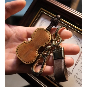 Exquisite brown leather violin keychain with golden hardware for a musical gift idea