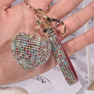 Detail eines bunten Strass-Herz-Schlüsselanhängers mit passender glitzernder Handschlaufe