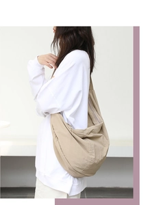 Dettaglio di una borsa a tracolla in nylon kaki che mostra tessuto e design minimalista