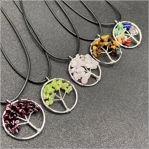 Macro detail of assorted colorful natural stone tree of life pendants with silver wire wrap