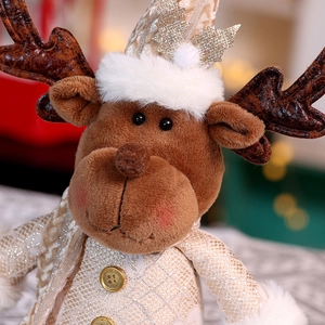 Macro detail of reindeer doll showing champagne gold antlers and festive sequin hat decoration