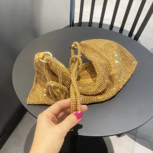 Close-up of gold rhinestone hobo bag with zipper and metallic ring handle details