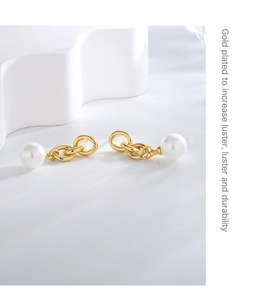 Detail view of gold-plated brass chain earrings with elegant white pearls on wavy base