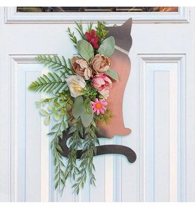 Detail of wooden cat silhouette wreath with faux roses and lush green foliage
