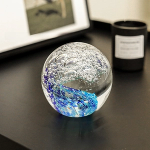 Macro detail of artistic blue ocean wave glass sphere with micro-bubble textures