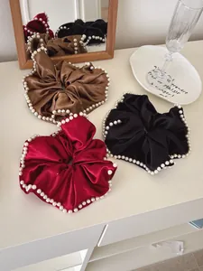Three-piece set of satin scrunchies with pearl edges in burgundy, black, and coffee brown