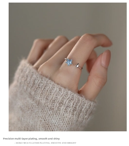 Detail of S925 silver star ring with blue zircon gemstone on a model's hand