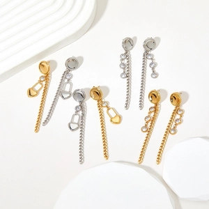 Minimalist gold and silver heart tassel earrings with zircon studs on white podiums