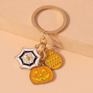 Detail of Halloween keychain showing enamel pumpkin spider web and yellow wave charms