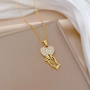 Gold titanium steel necklace featuring a dazzling heart and finger gesture pavé pendant