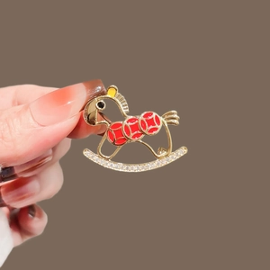 Detail of a rocking horse brooch with red enamel and pavé-set sparkling zircons