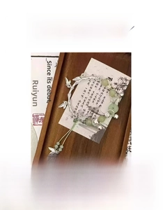 Close-up of bamboo style bracelet with butterfly and green resin beads on calligraphy paper