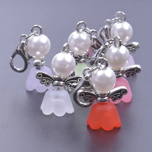 Detail of colorful angel wing charms with faux pearls and lobster clasps for favors