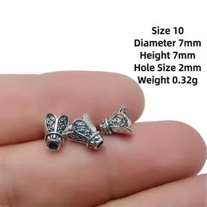 Macro view of 7mm antique silver bead spacers showing detailed relief and size scale