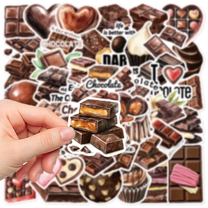 Close-up of a hand holding a chocolate graffiti sticker over a collection of waterproof decals