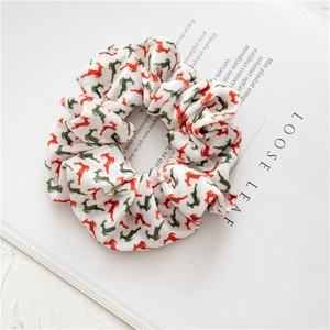 Detail of Christmas scrunchie featuring festive reindeer patterns on soft knit fabric