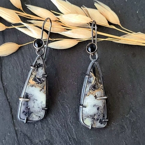 Macro-opname van vintage zilveren oorbellen met bumblebee jaspis en zwarte onyx