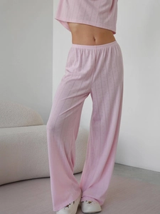 Detail of pink knitted loungewear set featuring a delicate hollow heart pattern texture