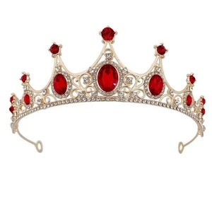Detail of a vintage golden alloy crown with sparkling rhinestones and red oval gemstones