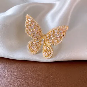 Elegant gold butterfly open ring with pink and white zircon stones on silk background
