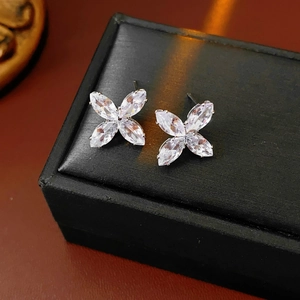 Gros plan de boucles d'oreilles fleur en argent avec zircons sur un écrin noir