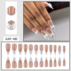 Long almond press-on nails with white French tips, 3D bows, and delicate pearl details