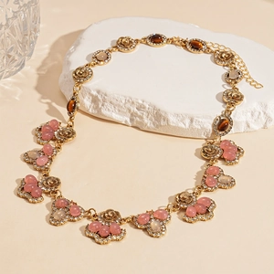 Close-up of vintage flower drop necklace with tiger eye resin and pink gemstones