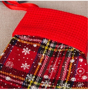 Close-up of red plaid Christmas stocking with white snowflake prints and knit cuff