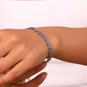 Macro shot of silver woven mesh strap bracelet with a high-polished metallic mirror finish