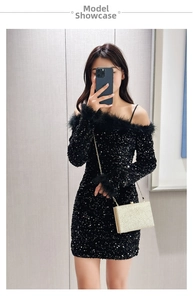 Detailed view of a small golden chain box bag paired with a black sequin feather dress
