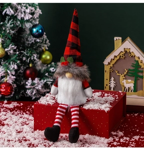 Close-up of a Christmas gnome doll with a red plaid hat sitting on a gift box
