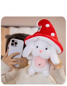 Détail d'un lapin en peluche blanc avec chapeau champignon rouge et étiquette violette