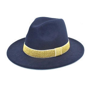 Detail of navy blue wool fedora with a shimmering gold glitter ribbon and buckle decor