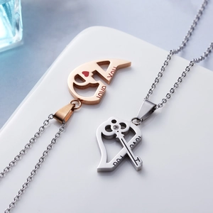 Macro detail of silver and gold stainless steel puzzle heart necklace with LOVE YOU engraving