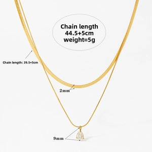 Close-up of double layer gold snake chain with a teardrop zircon pendant on white background