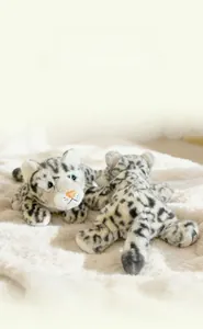 Close-up of realistic snow leopard plush toy with soft leopard print fur and blue eyes
