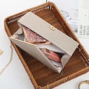 Bolso de noche dorado con purpurina y cadena, con pintalabios y teléfono en el interior