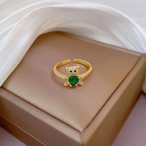 Detail of gold bear ring with heart-shaped green zircon on a luxury jewelry box