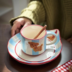 Detailed view of hand-painted ceramic dog coffee cup with blue stripes and wooden spoon