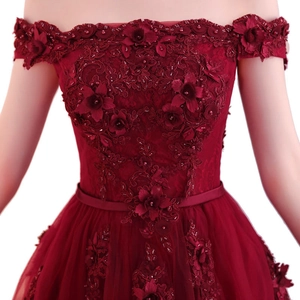 Texture de dentelle détaillée avec broderie florale 3D et perles sur robe de soirée bordeaux